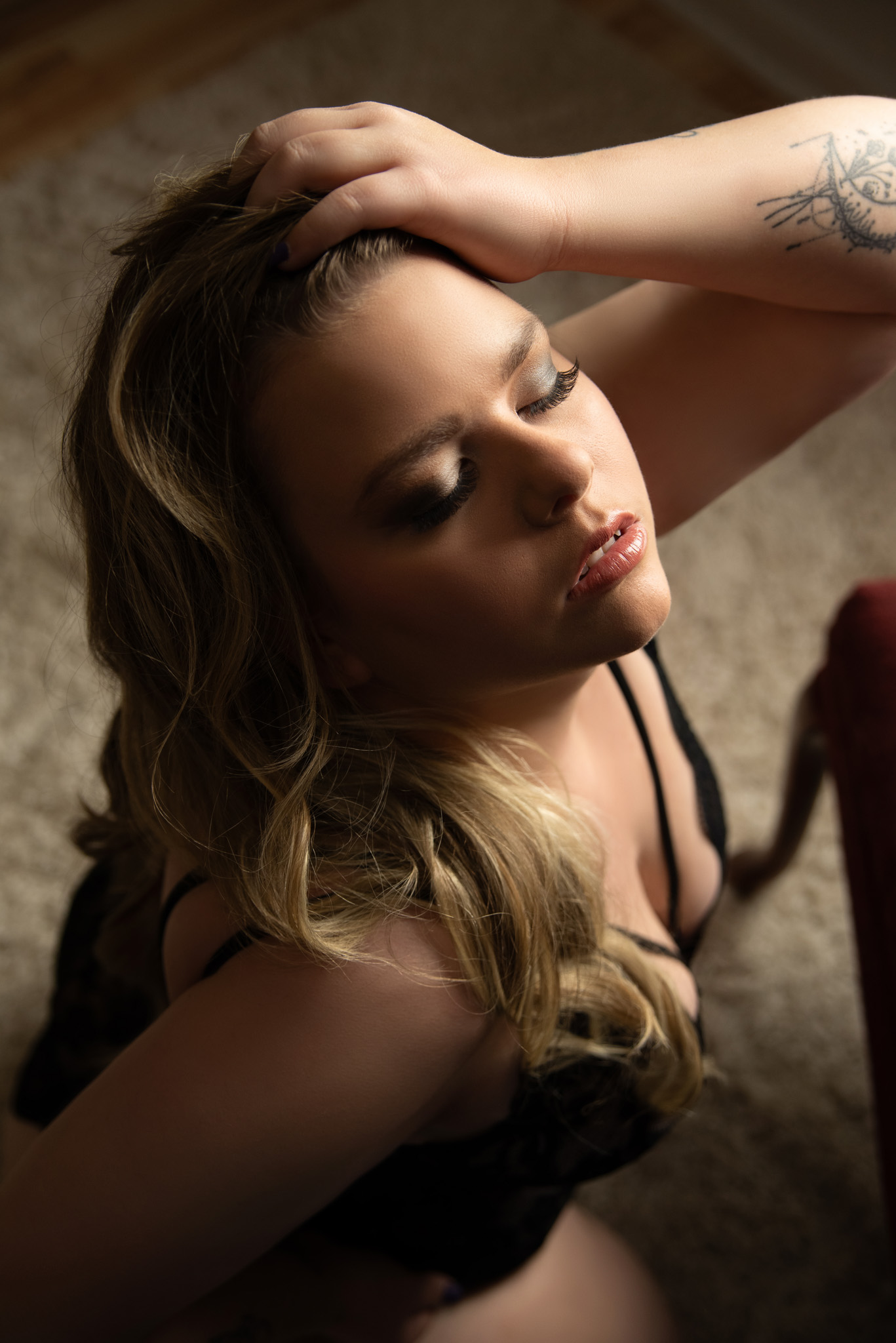 Woman kneeling with her head tipped back with her hand in her hair