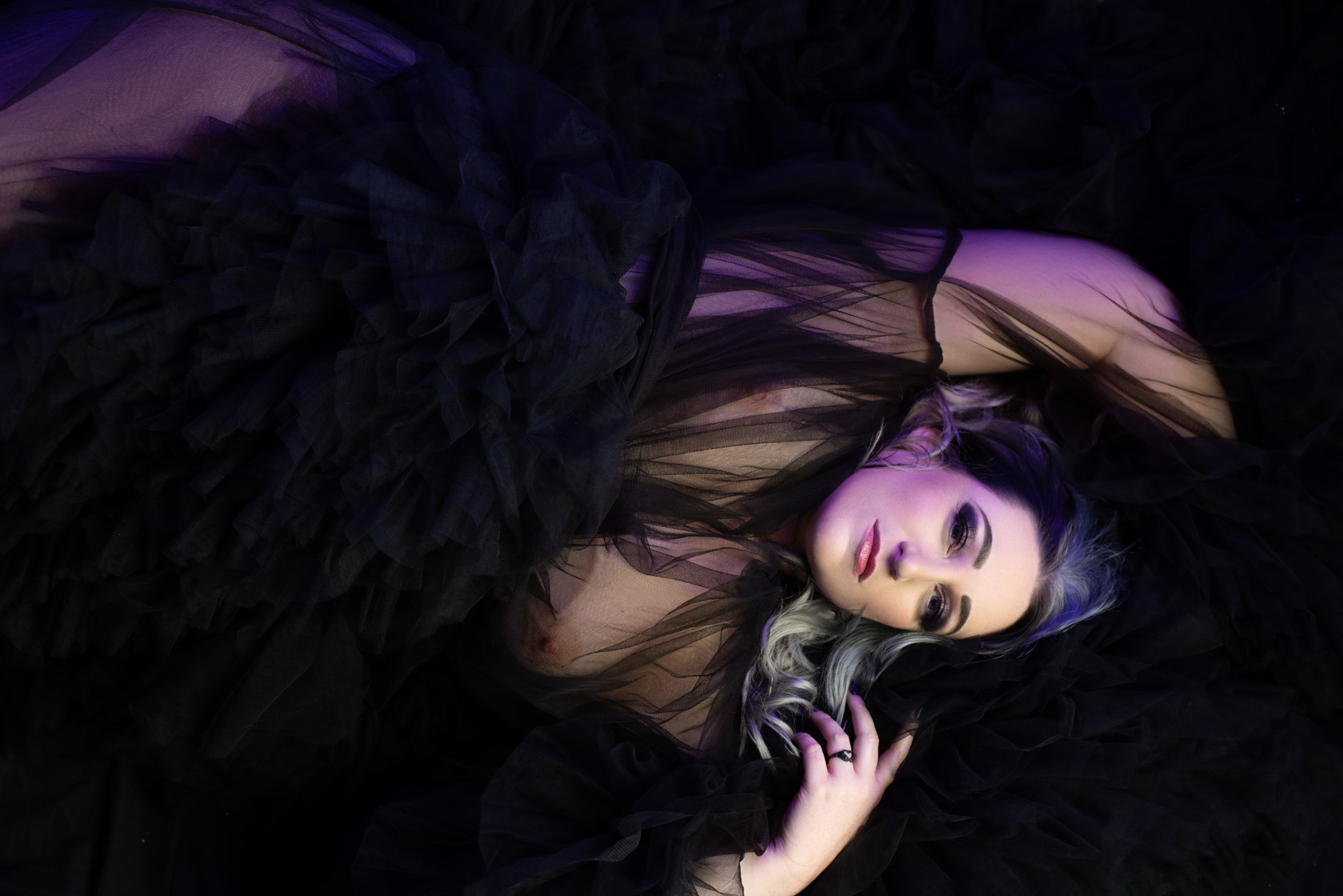 Plus sized woman lying down looking at the camera wearing fluffy robe