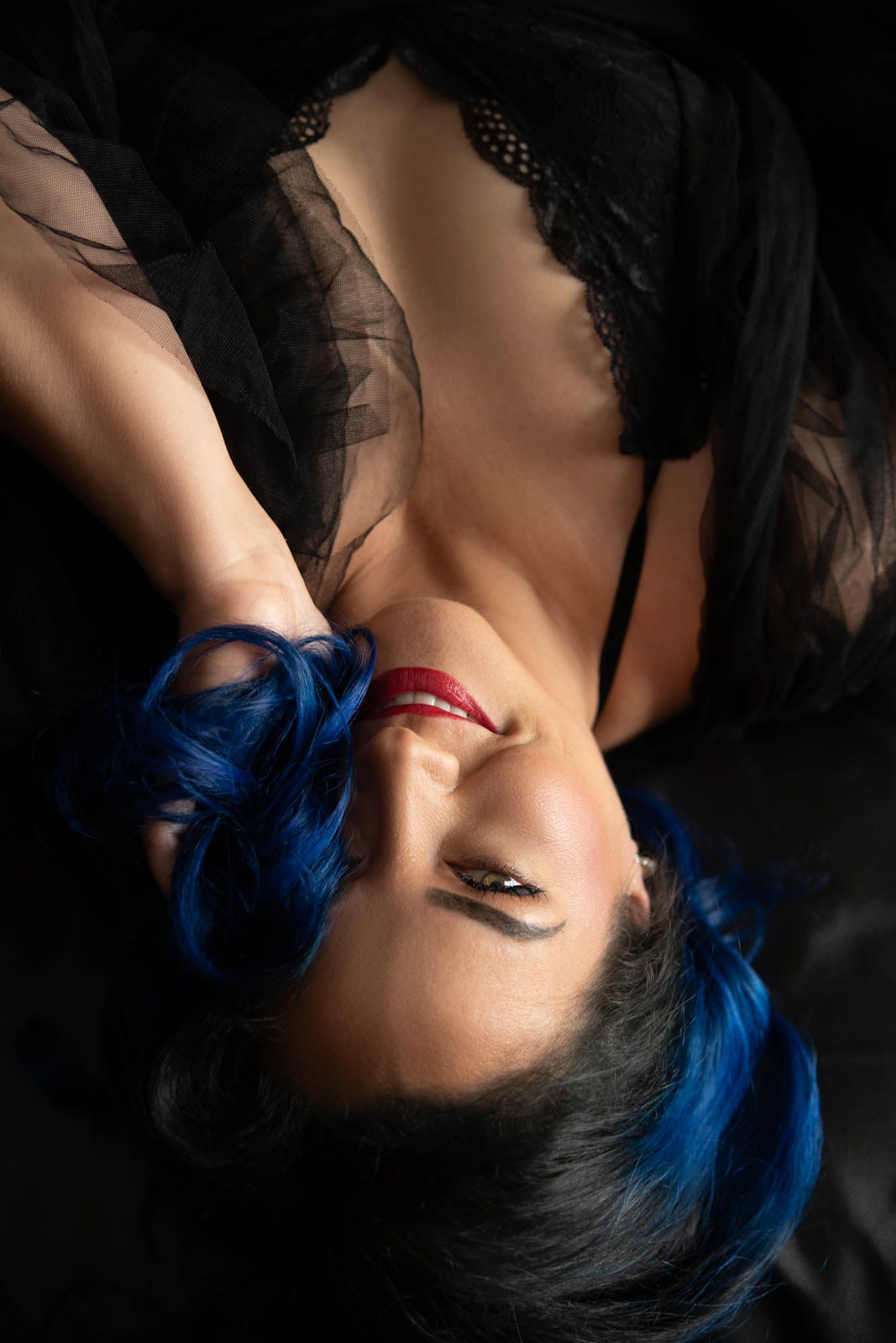 Flirty smile on a woman lying on her back and looking at the camera